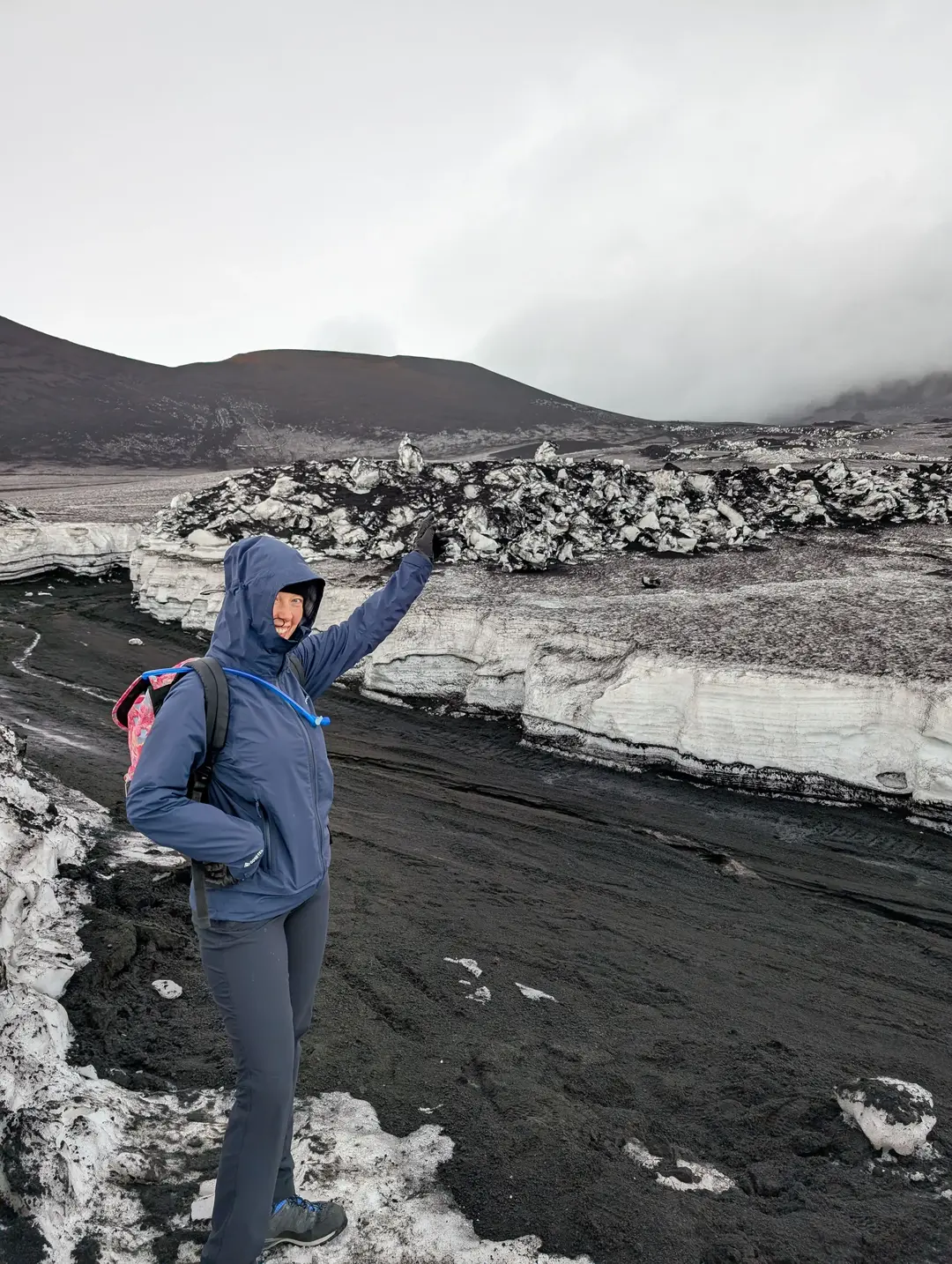 A walker pointing towards where Mount Etna would be if it wasn't so cloudy.