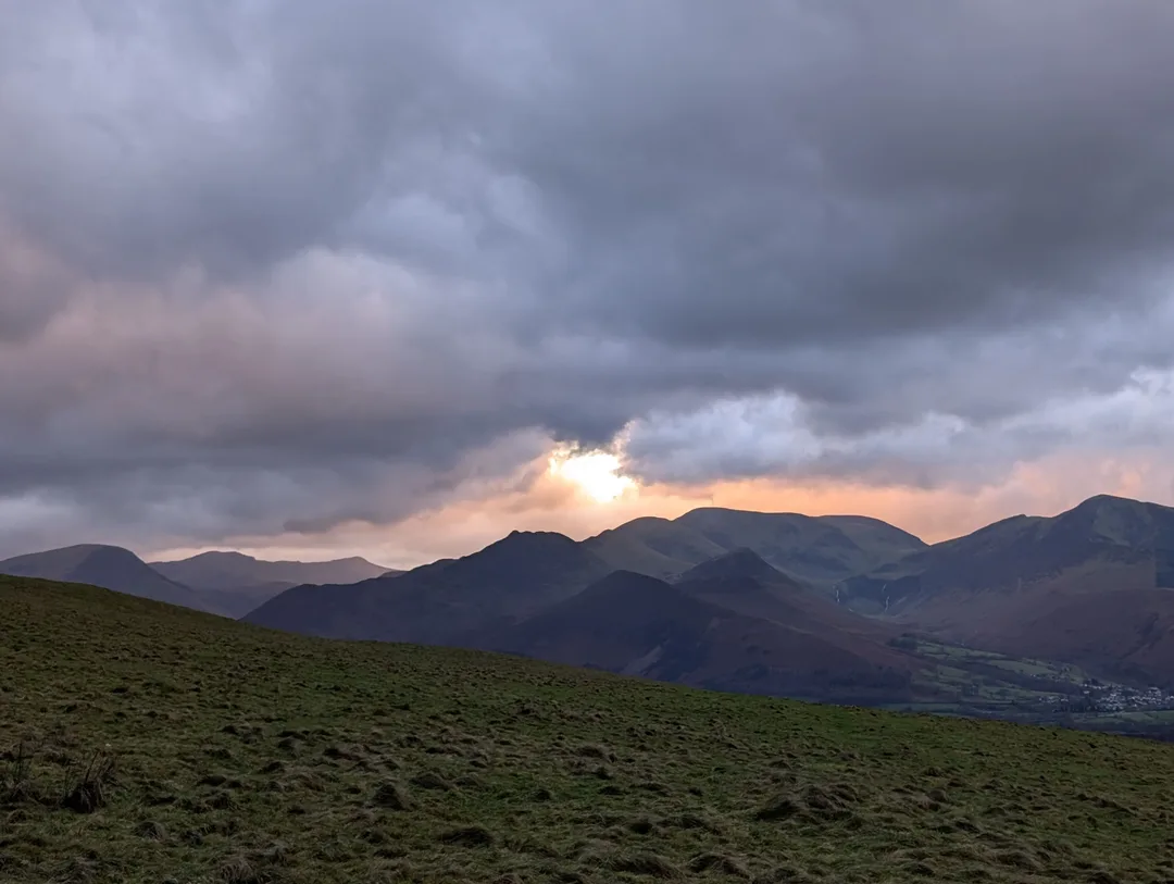 The sun setting behind stormy clouds